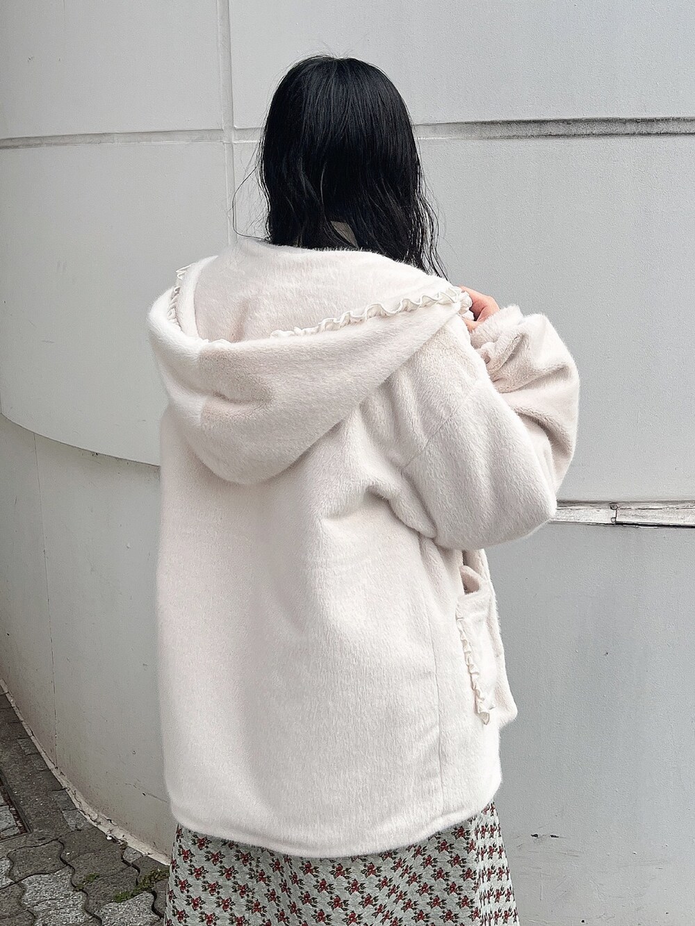 ホワイト系のニット/セーター、ホワイト系のダウンジャケット/コート、グリーン系のジャンパースカートを着用したレディースの冬コーディネートの6枚目の写真