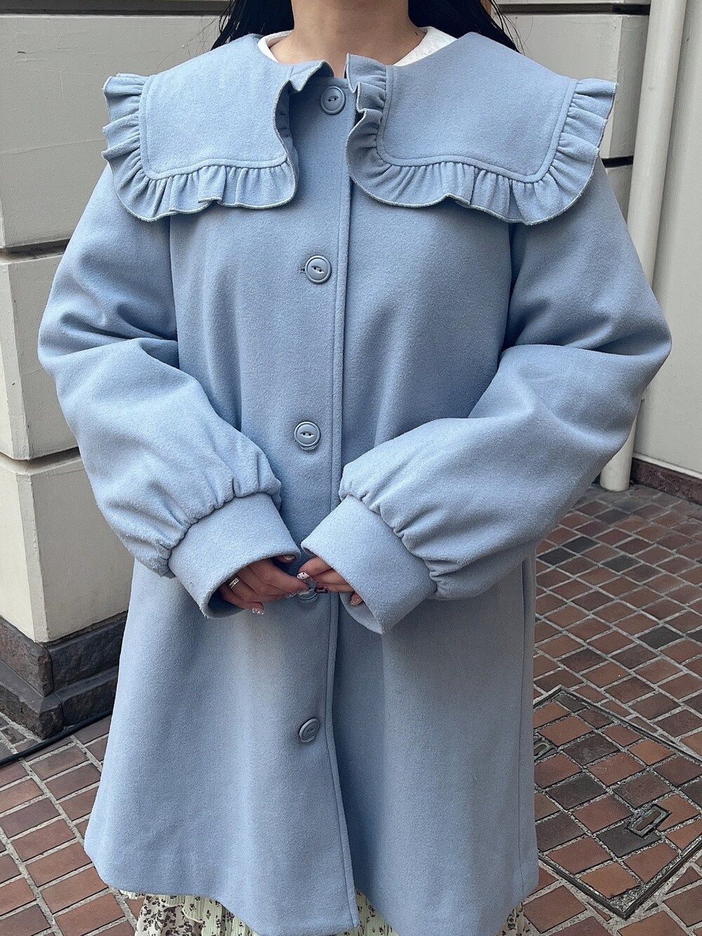 ブルー系のチェスターコート、グリーン系のスカート、ホワイト系のスニーカーを着用したレディースの冬コーディネートの6枚目の写真