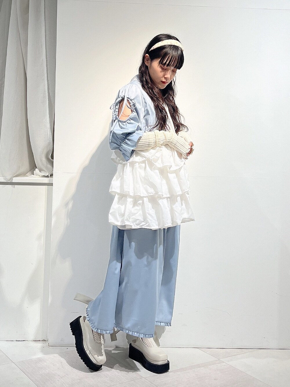 ブルー系のワンピース、ホワイト系のパンプス、ホワイト系のニット/セーターを着用したレディースの春コーディネートの2枚目の写真