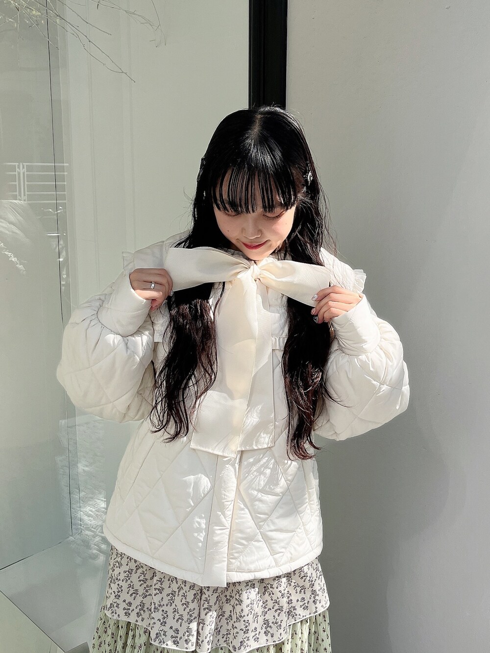 ホワイト系のダウンジャケット/コート、グリーン系のスカート、ホワイト系のスニーカーを着用したレディースの冬コーディネートの5枚目の写真