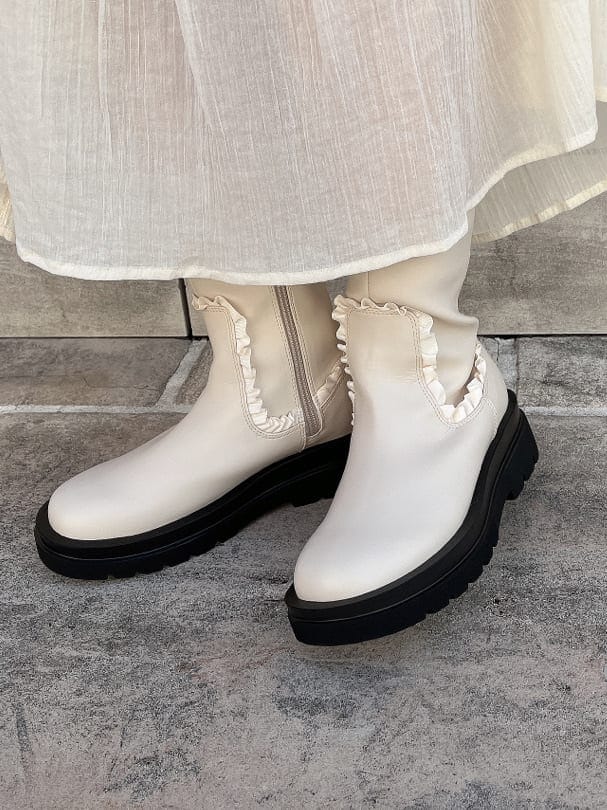 ホワイト系のニット/セーター、ホワイト系のワンピース、ホワイト系のブーツを着用したレディースの秋コーディネートの6枚目の写真