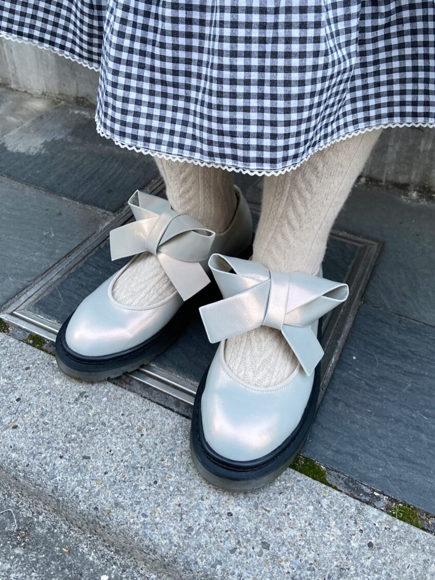 ホワイト系のパンプス、ホワイト系のシャツ/ブラウス、ブラック系のスカートを着用したレディースの冬コーディネートの6枚目の写真