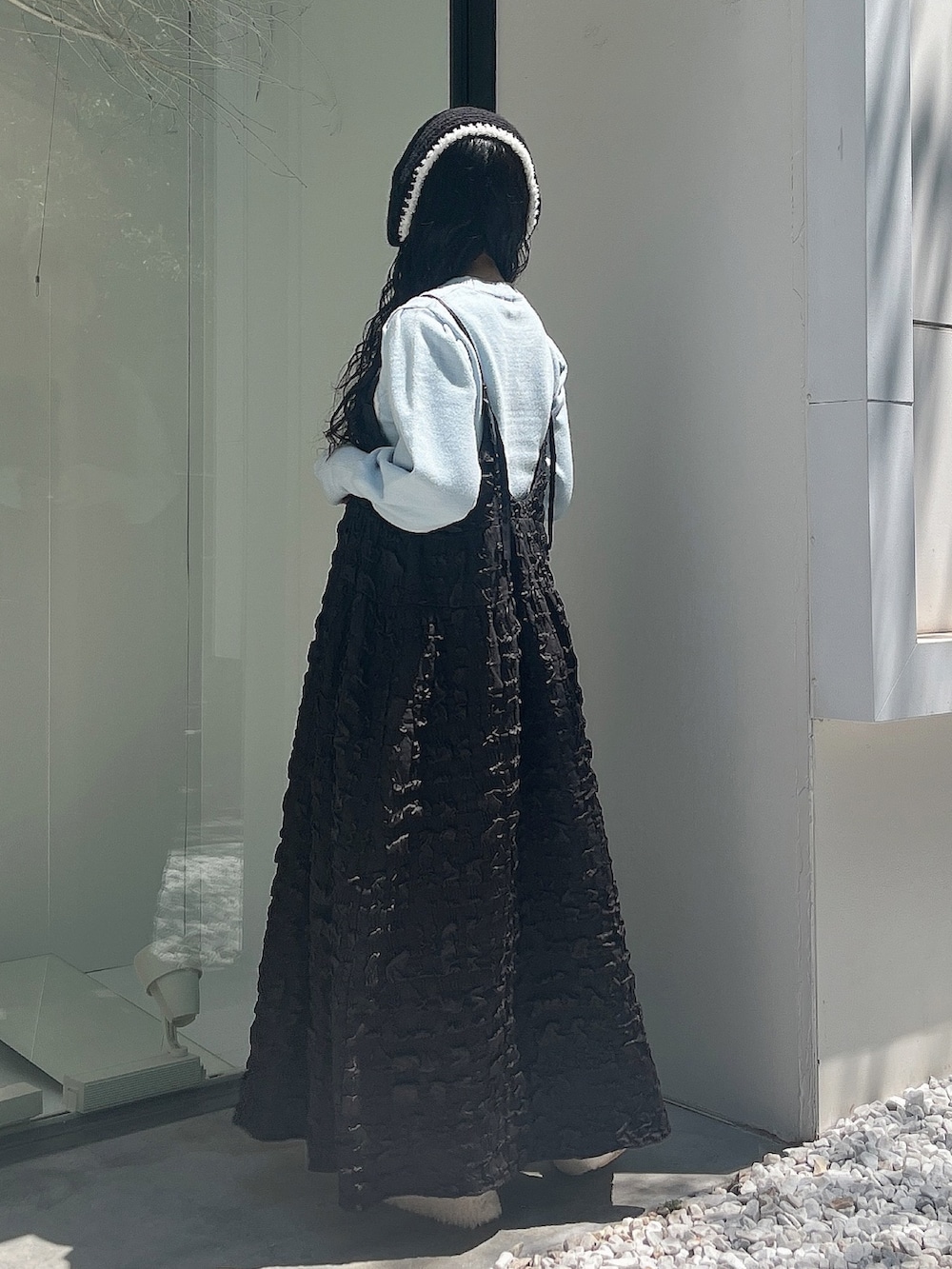 ブルー系のニット/セーター、ブラック系のワンピース、ホワイト系のスリッポンを着用したレディースの夏コーディネートの4枚目の写真