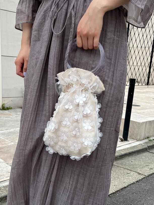 ホワイト系のパンプス、ホワイト系のハンドバッグ、グレー系のワンピースを着用したレディースの春コーディネートの6枚目の写真