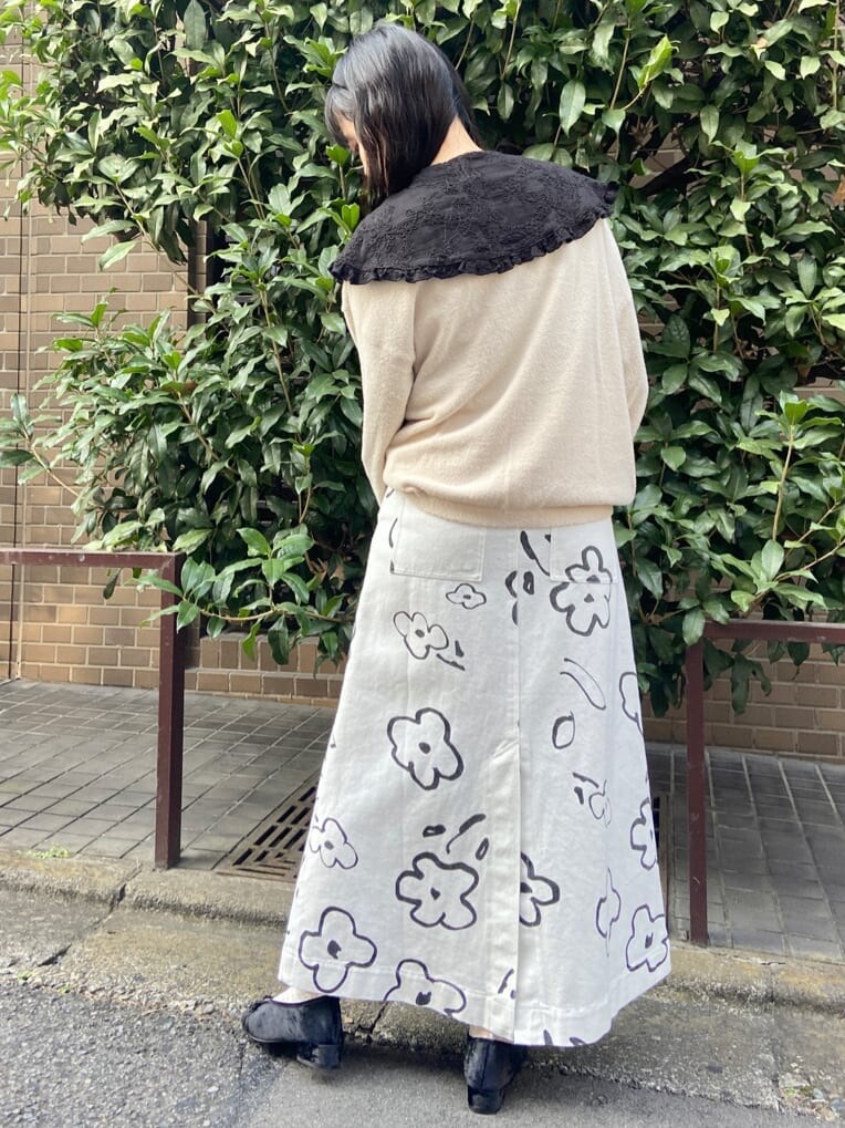 ブラック系のハンドバッグ、ホワイト系のカーディガン/ボレロ、ホワイト系のスカートを着用したレディースの秋コーディネートの3枚目の写真