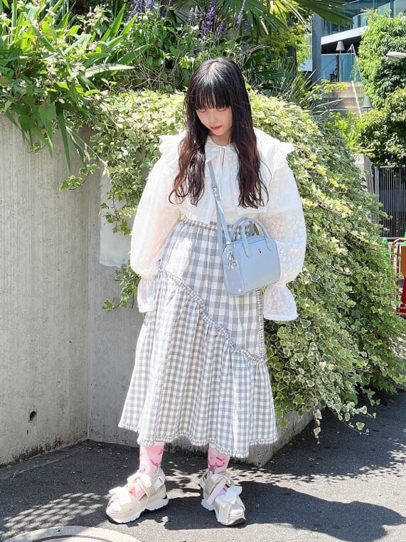 ホワイト系のサンダル、ブルー系のショルダーバッグ、ホワイト系のTシャツ/カットソーを着用したレディースの夏コーディネートの2枚目の写真