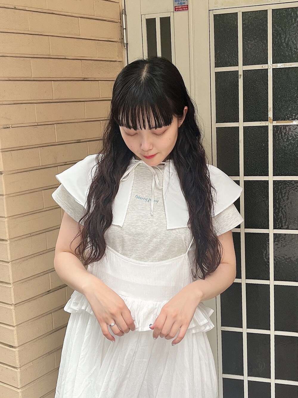 グレー系のTシャツ/カットソー、ホワイト系のスカート、ブルー系のサンダルを着用したレディースの夏コーディネートの4枚目の写真