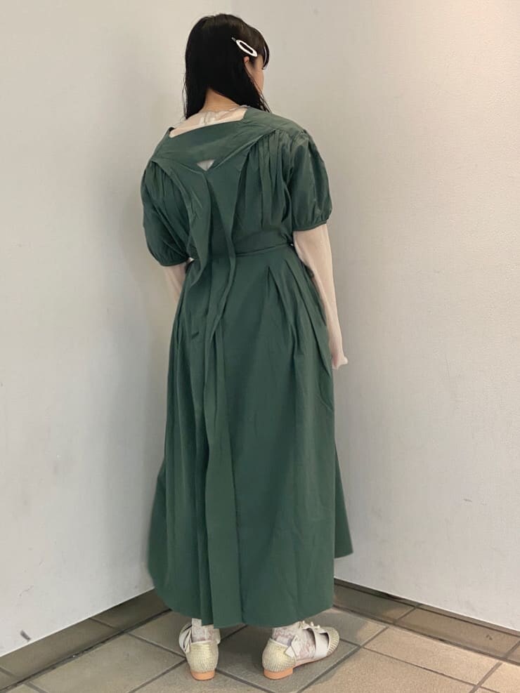 ベージュ系のパンプス、グリーン系のワンピース、ホワイト系のチュニックを着用したレディースの夏コーディネートの3枚目の写真