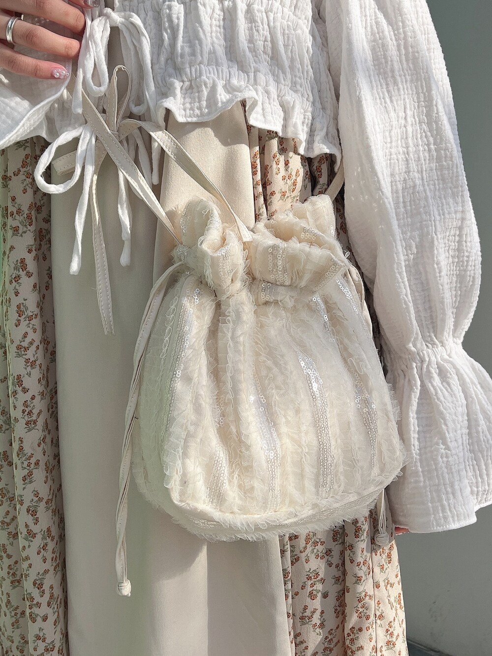 ベージュ系のワンピース、ホワイト系のシャツ/ブラウス、ホワイト系のショルダーバッグを着用したレディースの冬コーディネートの7枚目の写真