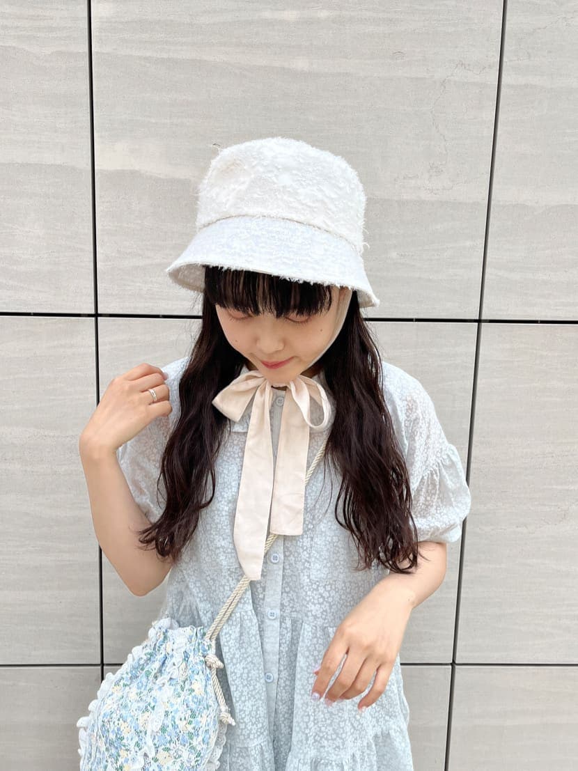 ブルー系のハンドバッグ、ホワイト系のサンダル、ブルー系のワンピースを着用したレディースの夏コーディネートの2枚目の写真