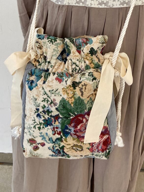 ベージュ系のワンピース、ホワイト系のパンプス、ホワイト系のハンドバッグを着用したレディースの夏コーディネートの6枚目の写真