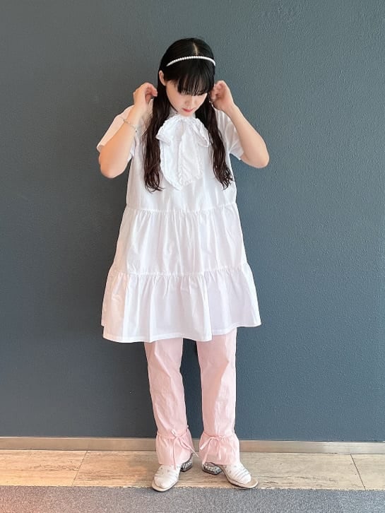 ベージュ系のサンダル、ピンク系のスラックス、ホワイト系のワンピースを着用したレディースの夏コーディネートの2枚目の写真