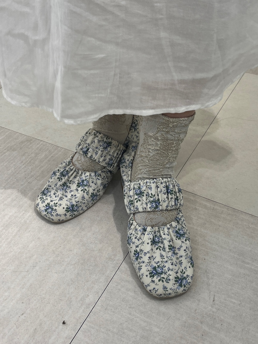 ブルー系のTシャツ/カットソー、ホワイト系のワンピース、ホワイト系のパンプスを着用したレディースの秋コーディネートの7枚目の写真