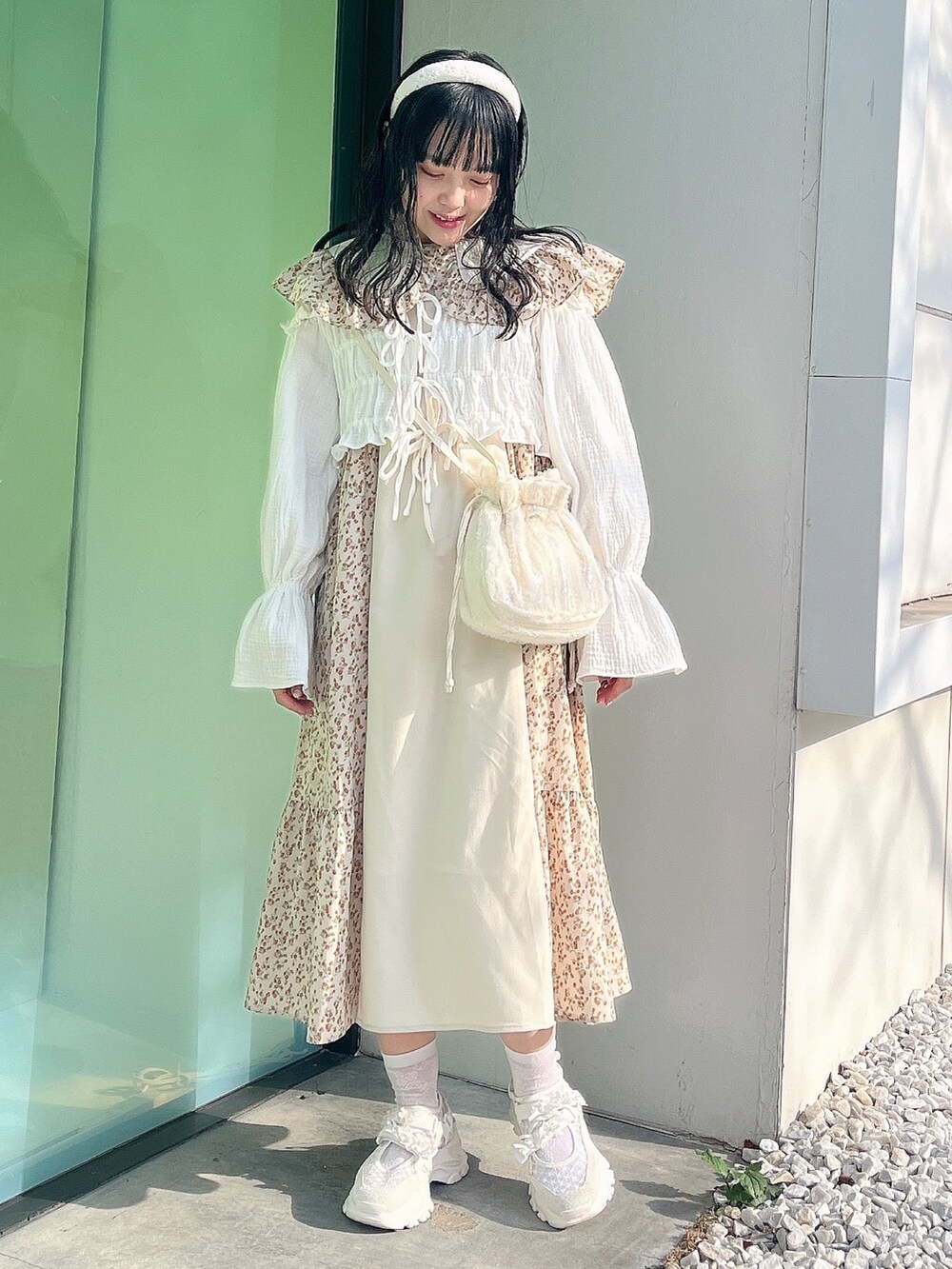 ベージュ系のワンピース、ホワイト系のシャツ/ブラウス、ホワイト系のショルダーバッグを着用したレディースの冬コーディネートの2枚目の写真