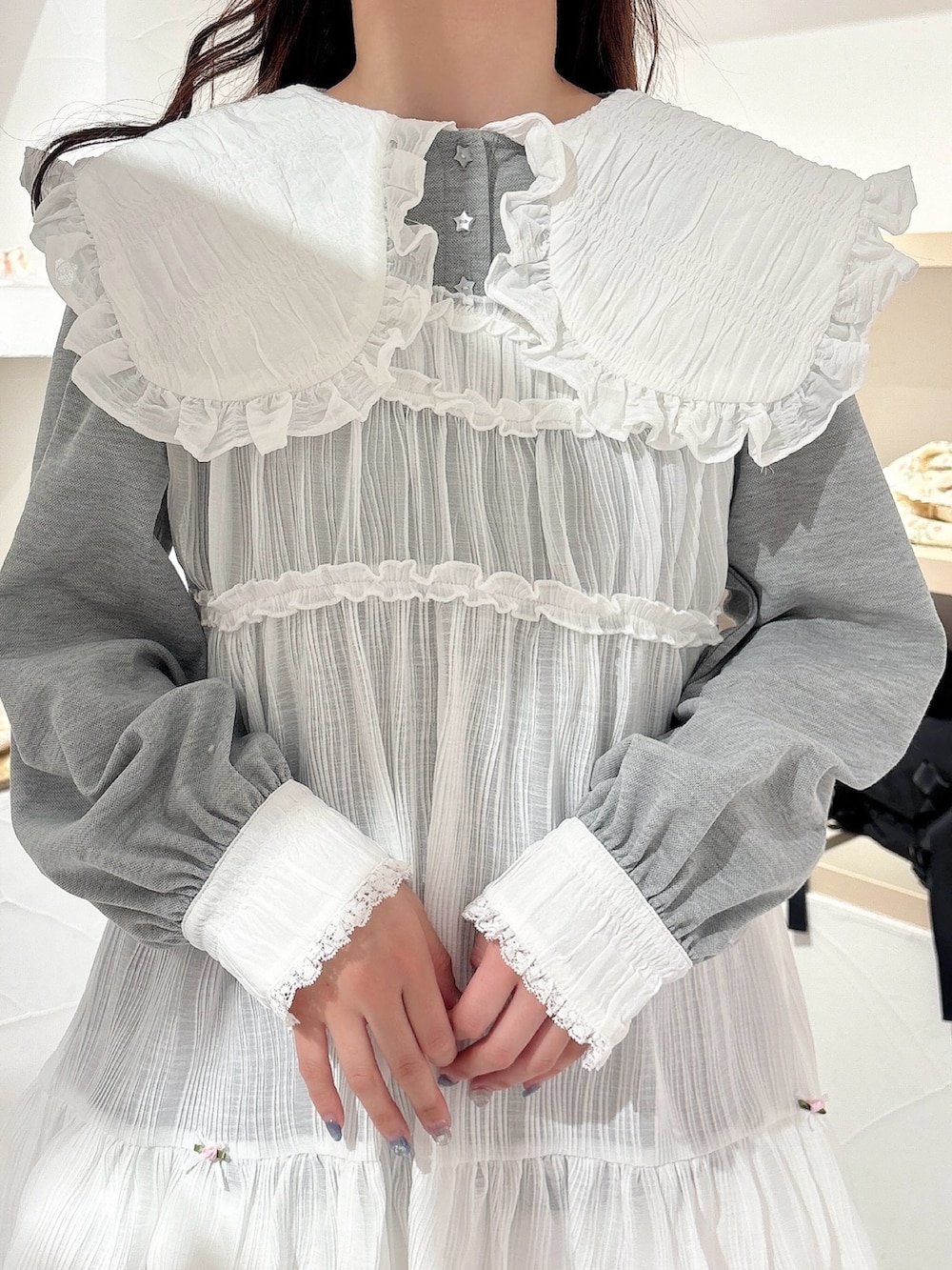 ホワイト系のチュニック、グレー系のワンピース、ホワイト系のその他パンツを着用したレディースの冬コーディネートの6枚目の写真