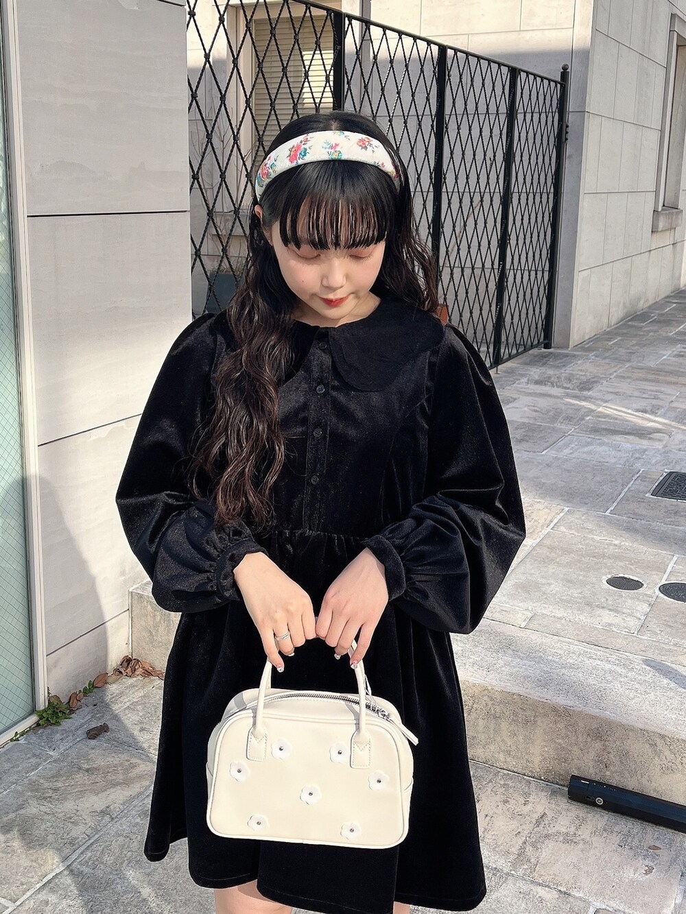 ブラック系のワンピース、ホワイト系のボストンバッグ、ブラック系のブーツを着用したレディースの冬コーディネートの4枚目の写真