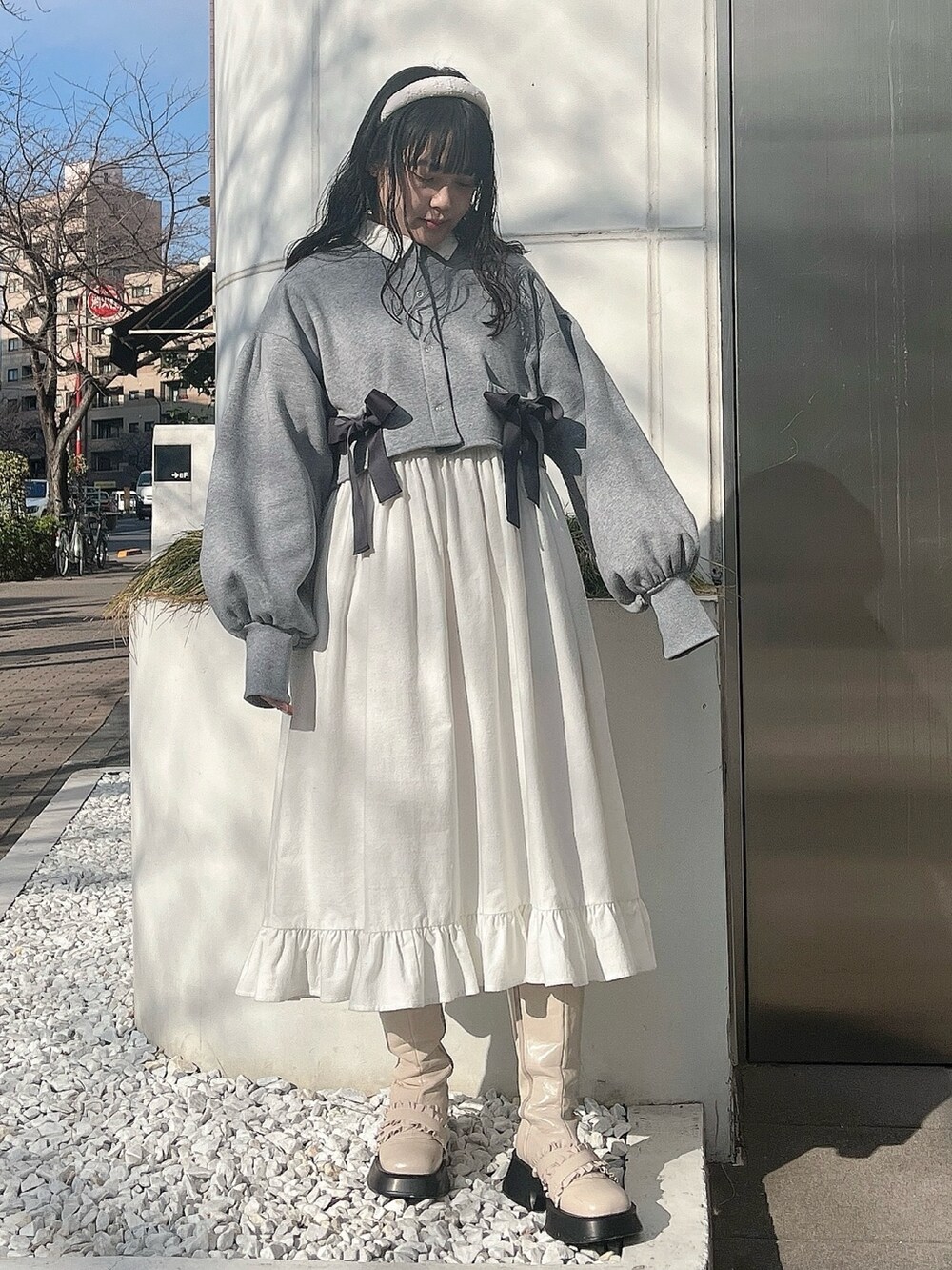 グレー系のカーディガン/ボレロ、ホワイト系のワンピース、ホワイト系のブーツを着用したレディースの冬コーディネートの3枚目の写真