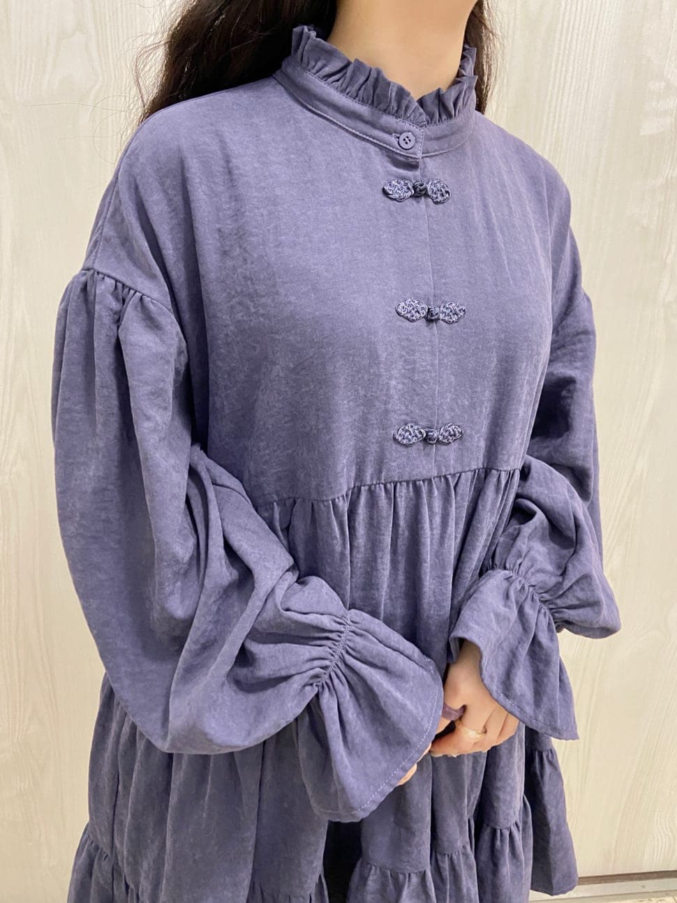 ブルー系のナイロンジャケット、パープル系のワンピース、ブラック系のブーツを着用したレディースの冬コーディネートの6枚目の写真