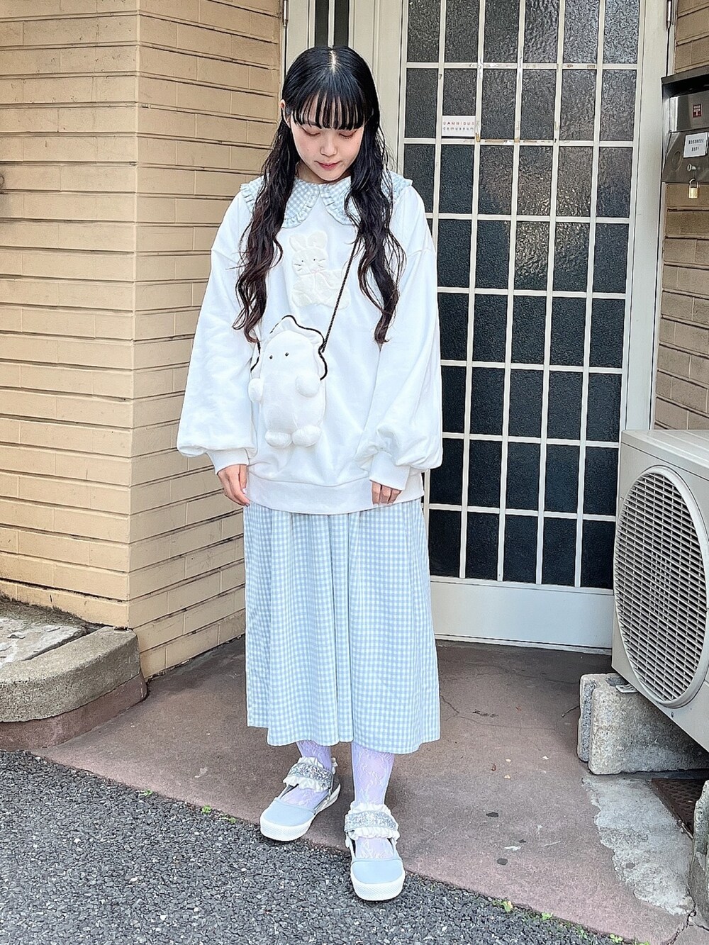 ホワイト系のスウェット、ホワイト系のショルダーバッグ、ブルー系のワンピースを着用したレディースの冬コーディネートの2枚目の写真