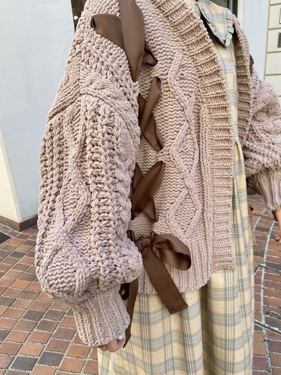 ベージュ系のワンピース、ホワイト系のパンプス、ブラウン系のカーディガン/ボレロを着用したレディースの秋コーディネートの5枚目の写真