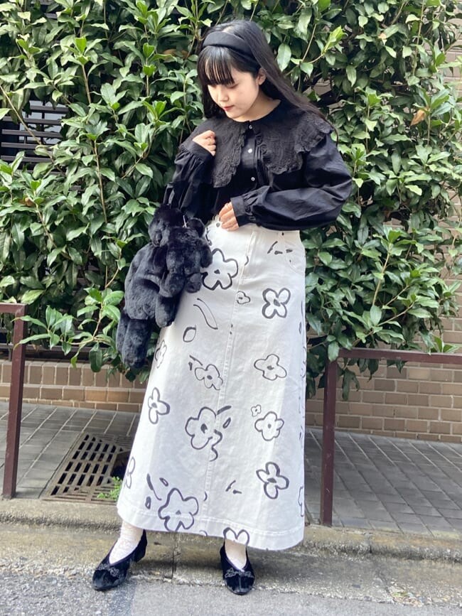 ブラック系のハンドバッグ、ホワイト系のカーディガン/ボレロ、ホワイト系のスカートを着用したレディースの秋コーディネートの4枚目の写真