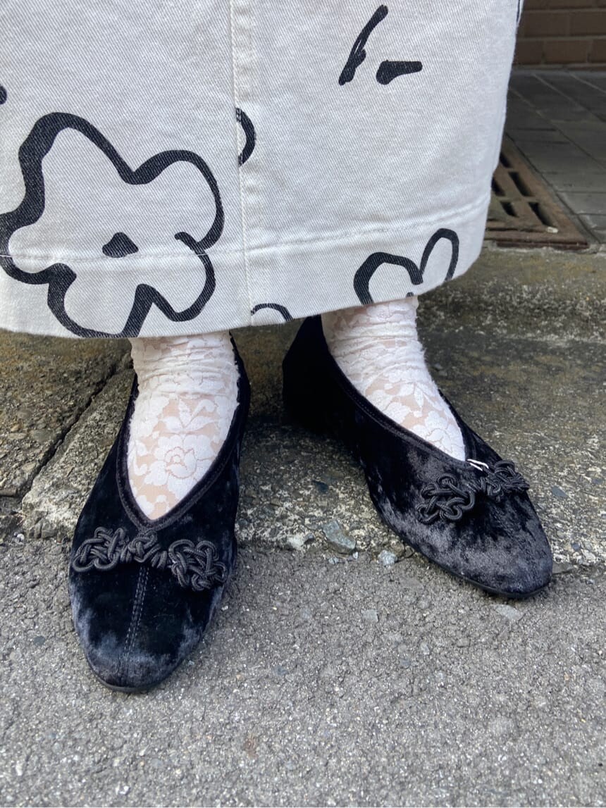 ブラック系のハンドバッグ、ホワイト系のカーディガン/ボレロ、ホワイト系のスカートを着用したレディースの秋コーディネートの8枚目の写真