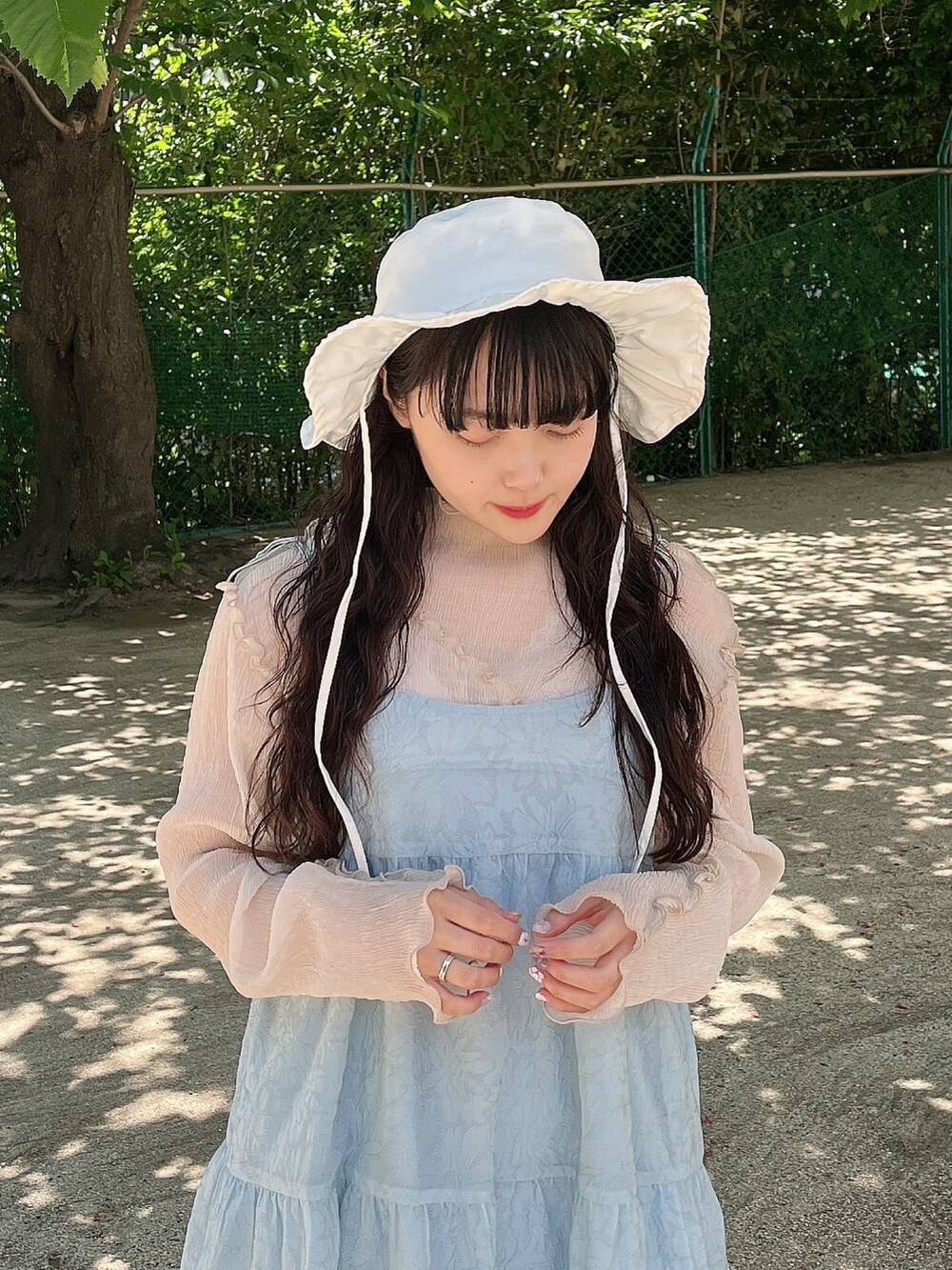 ブルー系のワンピース、ベージュ系のTシャツ/カットソー、ホワイト系のパンプスを着用したレディースの夏コーディネートの4枚目の写真