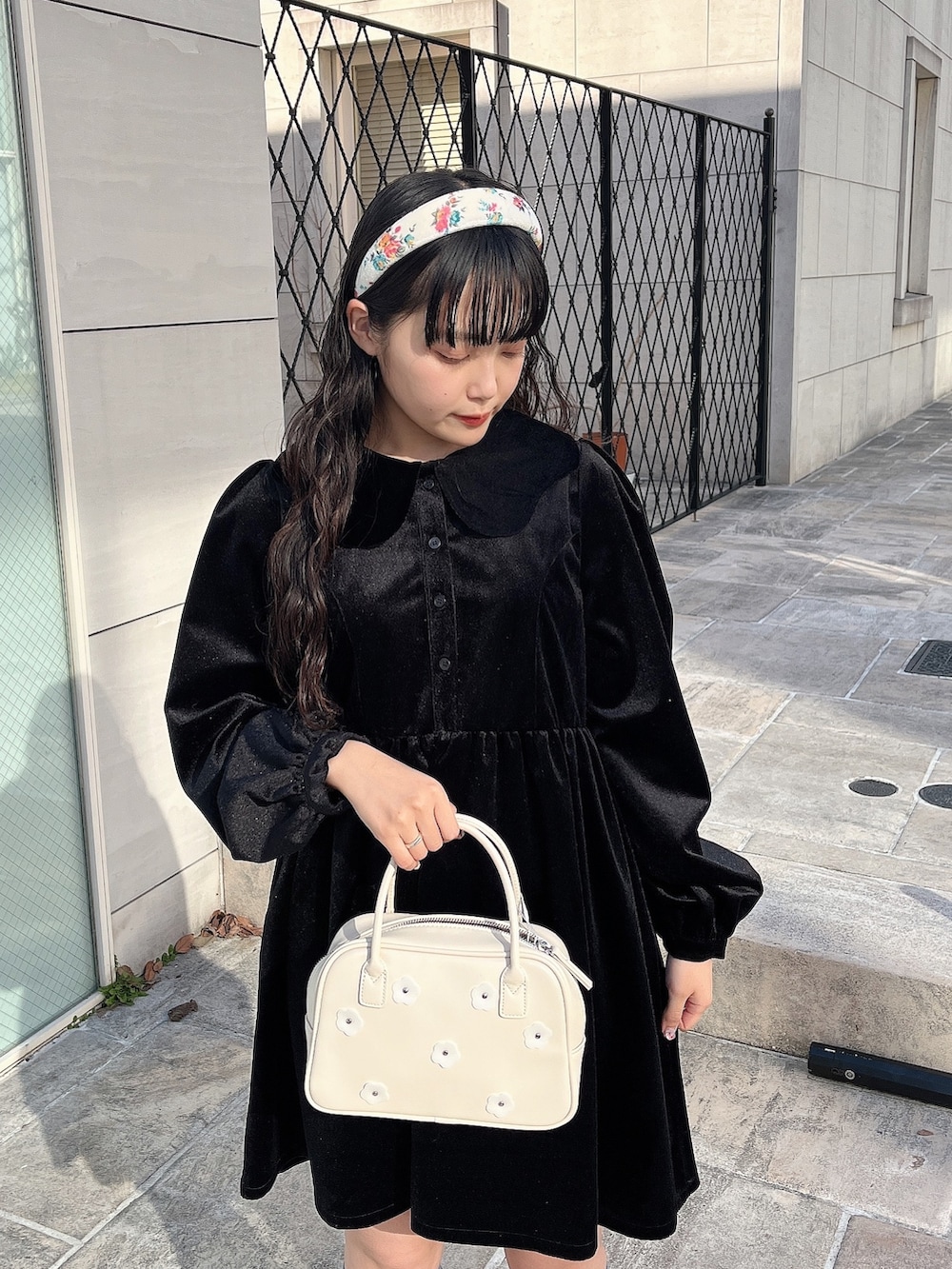 ブラック系のワンピース、ホワイト系のボストンバッグ、ブラック系のブーツを着用したレディースの冬コーディネートの5枚目の写真