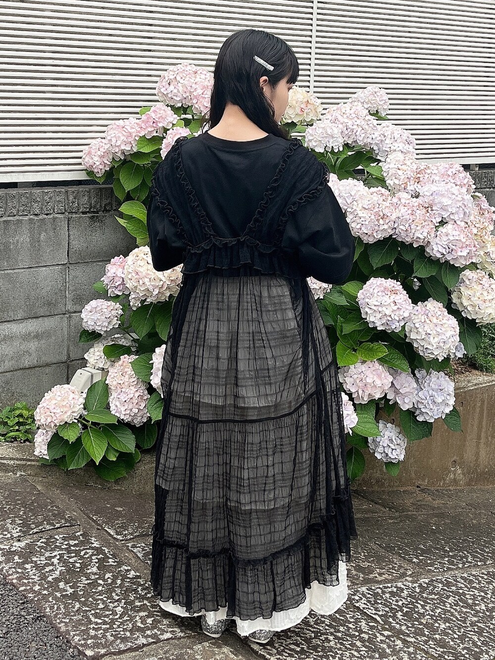 ブラック系のTシャツ/カットソー、シルバー系のパンプス、ホワイト系のスカートを着用したレディースの夏コーディネートの3枚目の写真