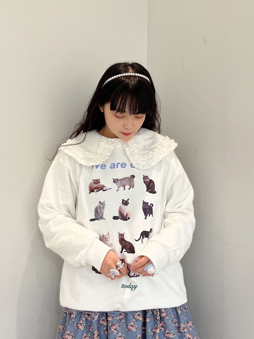 ホワイト系のシャツ/ブラウス、ホワイト系のスウェット、ブルー系のジャンパースカートを着用したレディースの秋コーディネートの2枚目の写真