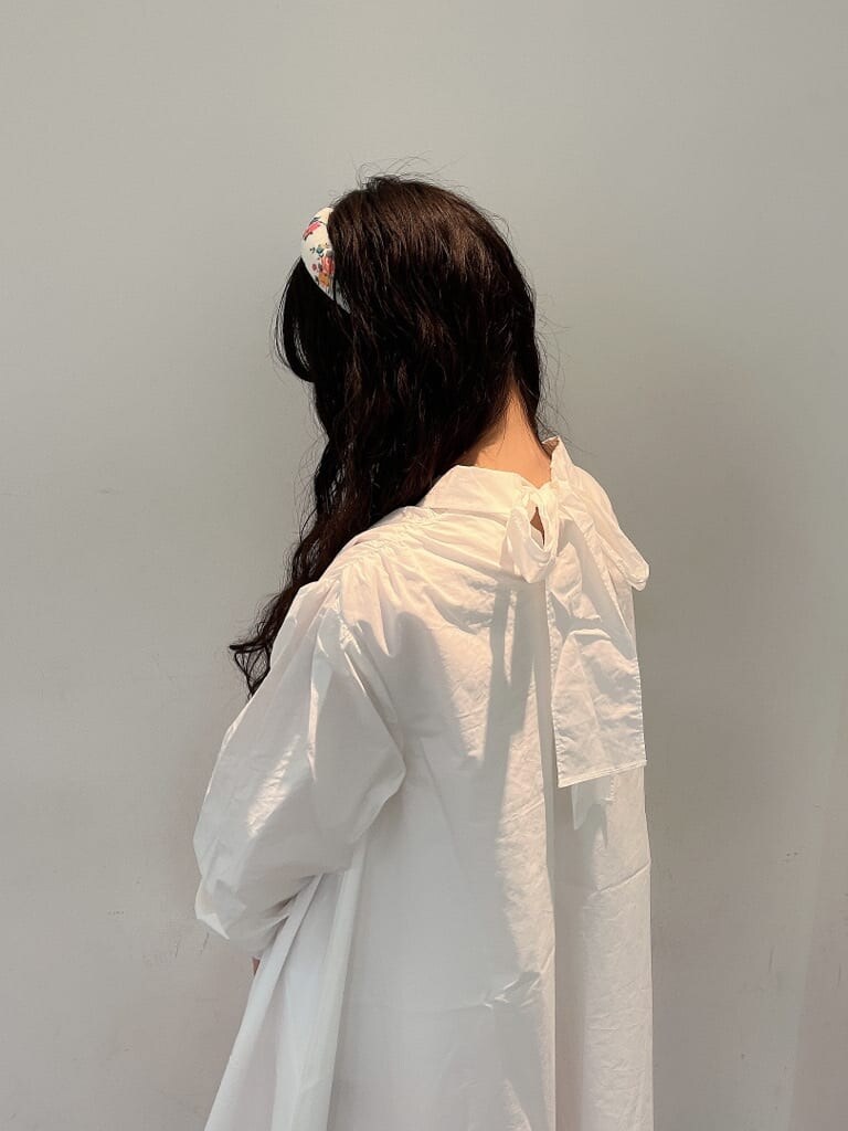 ピンク系のスラックス、ホワイト系のワンピース、ベージュ系のサンダルを着用したレディースの夏コーディネートの5枚目の写真