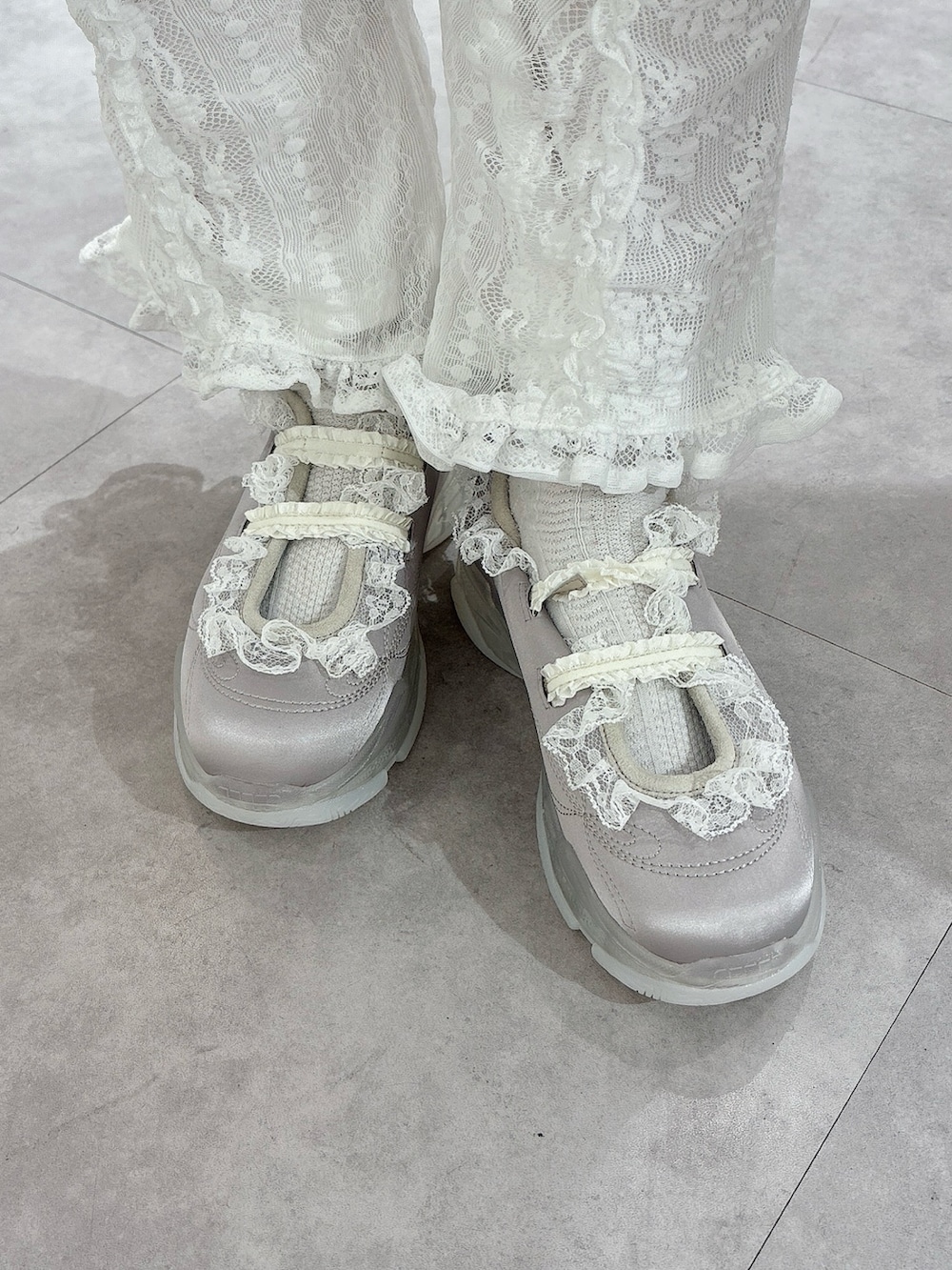 グレー系のワンピース、ホワイト系のその他パンツ、ブルー系のスニーカーを着用したレディースの冬コーディネートの6枚目の写真