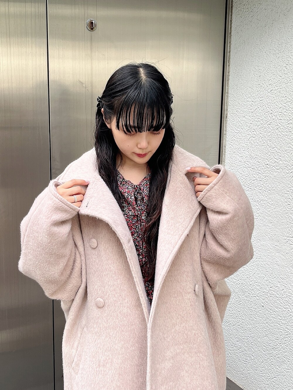ピンク系のワンピース、ホワイト系のチェスターコート、ホワイト系のスニーカーを着用したレディースの秋コーディネートの4枚目の写真