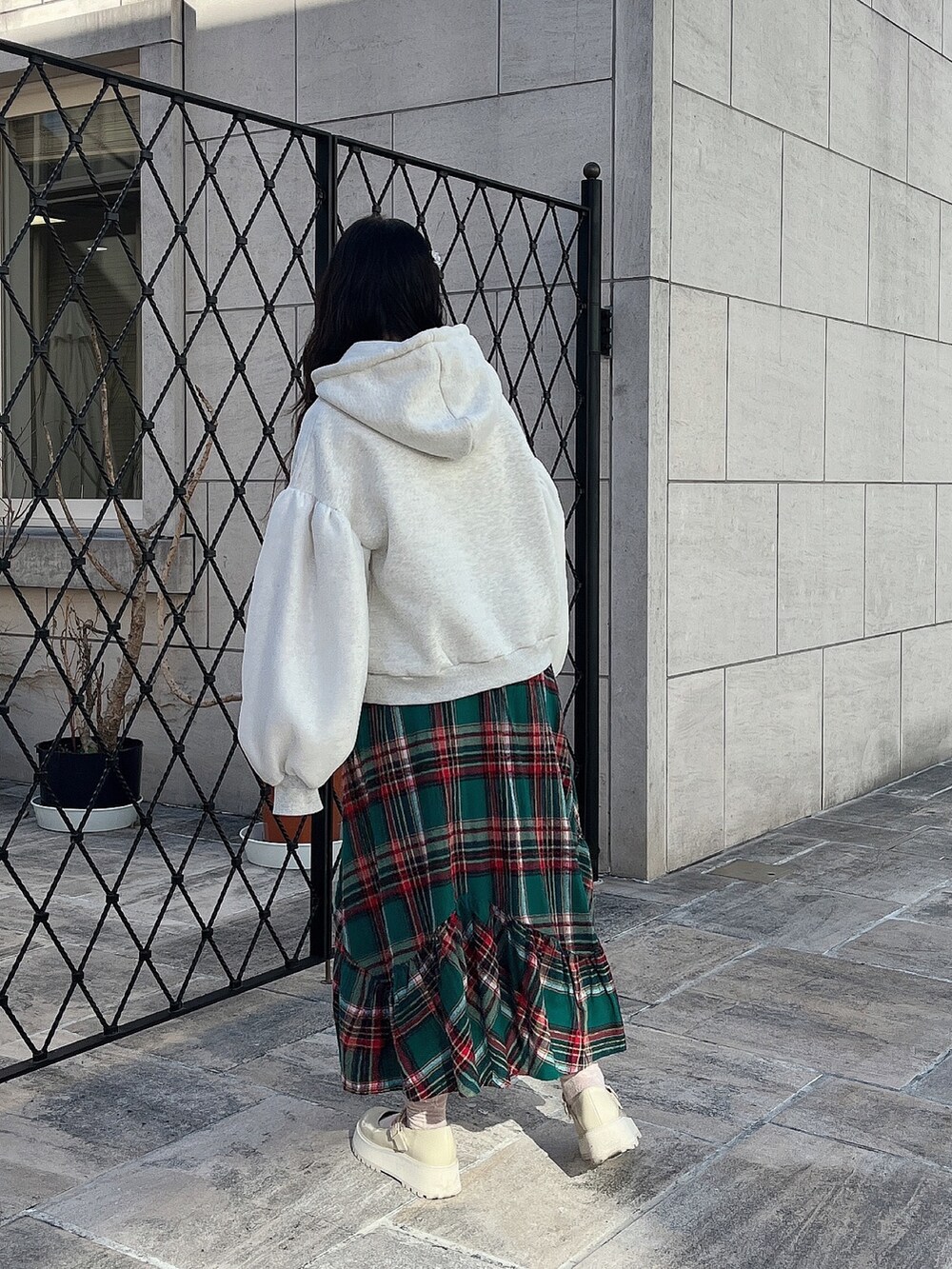 ホワイト系のパーカー、ホワイト系のその他アウター、グリーン系のスカートを着用したレディースの冬コーディネートの5枚目の写真