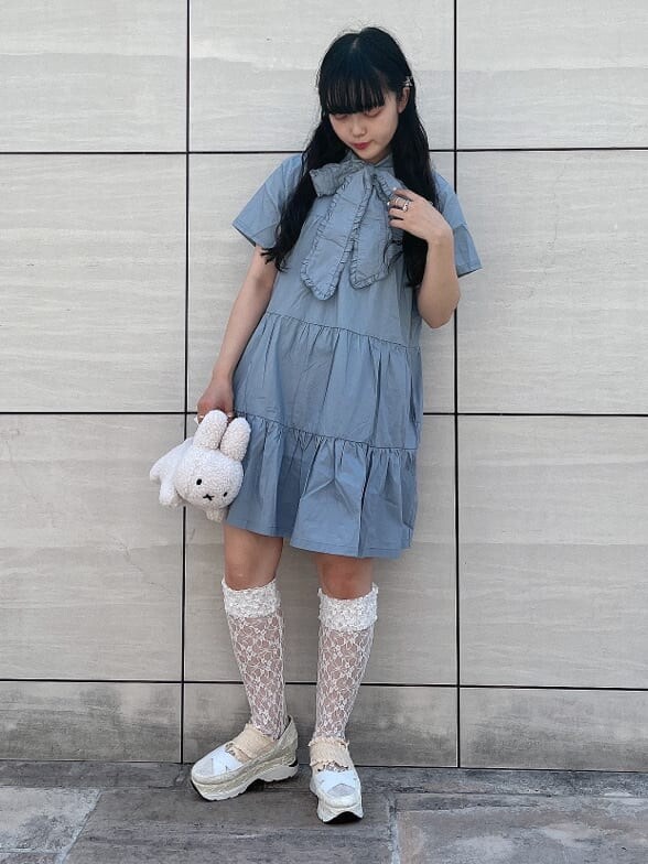 ホワイト系のスニーカー、ホワイト系のハンドバッグ、ブルー系のワンピースを着用したレディースの夏コーディネートの2枚目の写真