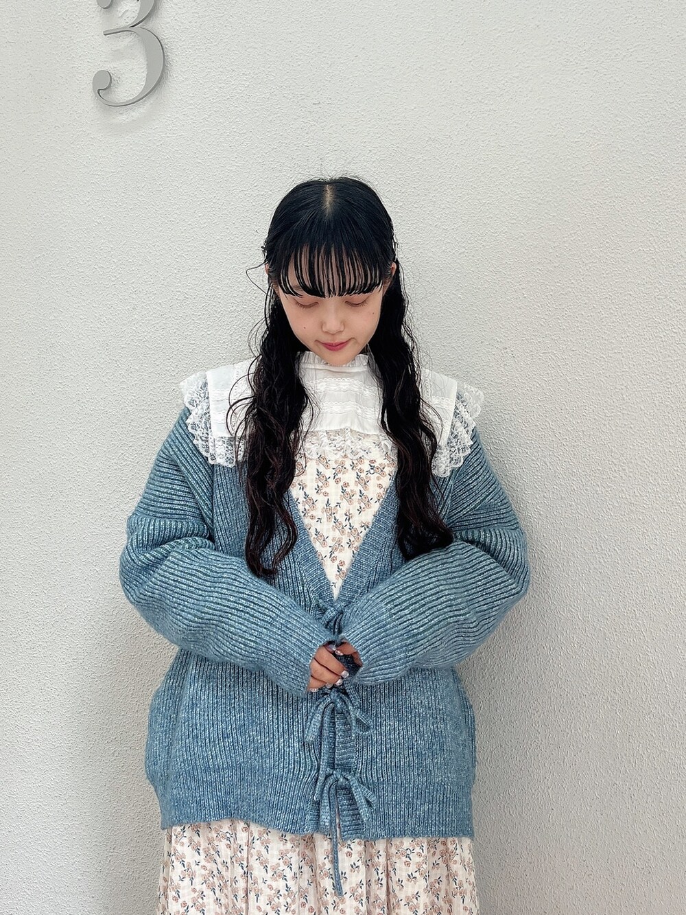 ホワイト系のワンピース、ブルー系のカーディガン/ボレロ、ホワイト系のスニーカーを着用したレディースの秋コーディネートの6枚目の写真