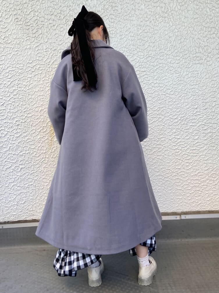 ブルー系のステンカラーコート、ホワイト系のシャツ/ブラウス、ブラック系のスカートを着用したレディースの秋コーディネートの2枚目の写真