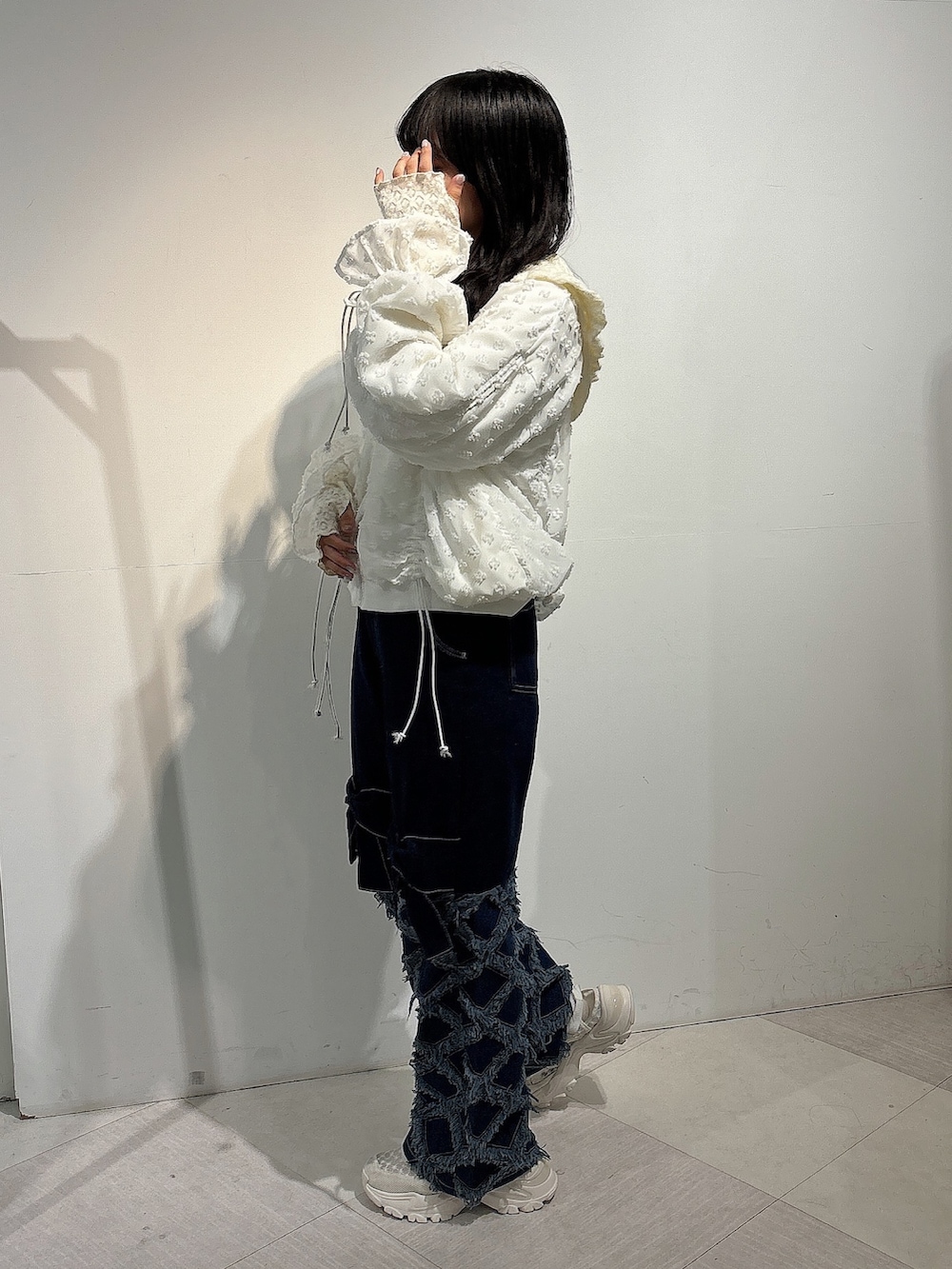 ホワイト系のジャージ、ブルー系のデニムパンツ、ホワイト系のスニーカーを着用したレディースの秋コーディネートの3枚目の写真