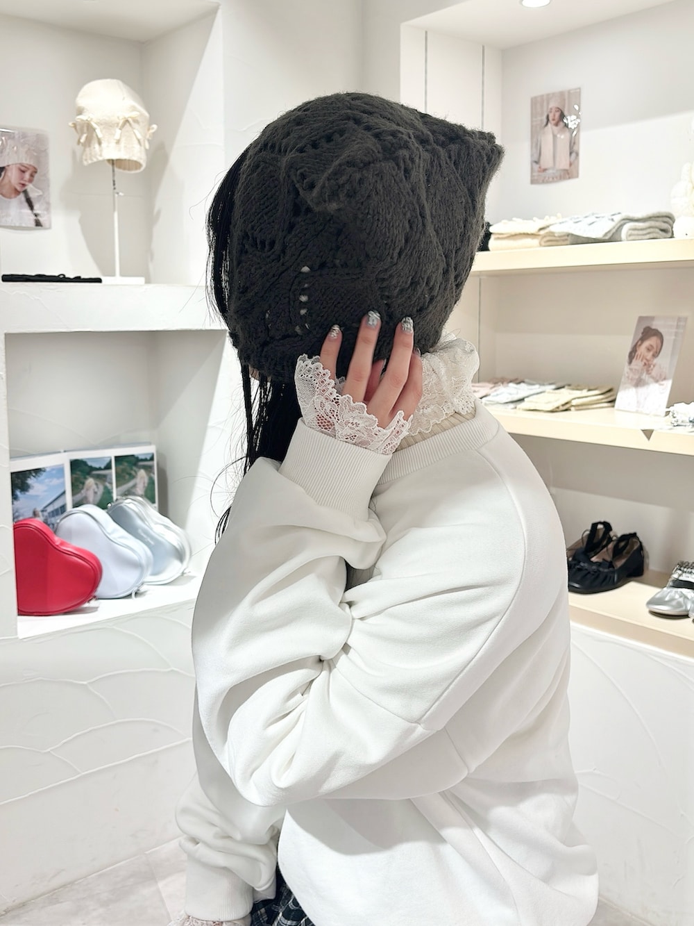 ホワイト系のニット/セーター、ホワイト系のスウェット、ブラック系のスカートを着用したレディースの秋コーディネートの6枚目の写真