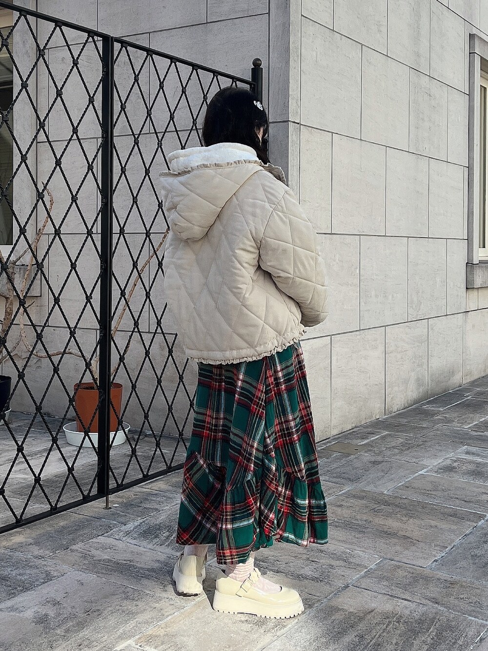 ホワイト系のパーカー、ホワイト系のその他アウター、グリーン系のスカートを着用したレディースの冬コーディネートの3枚目の写真