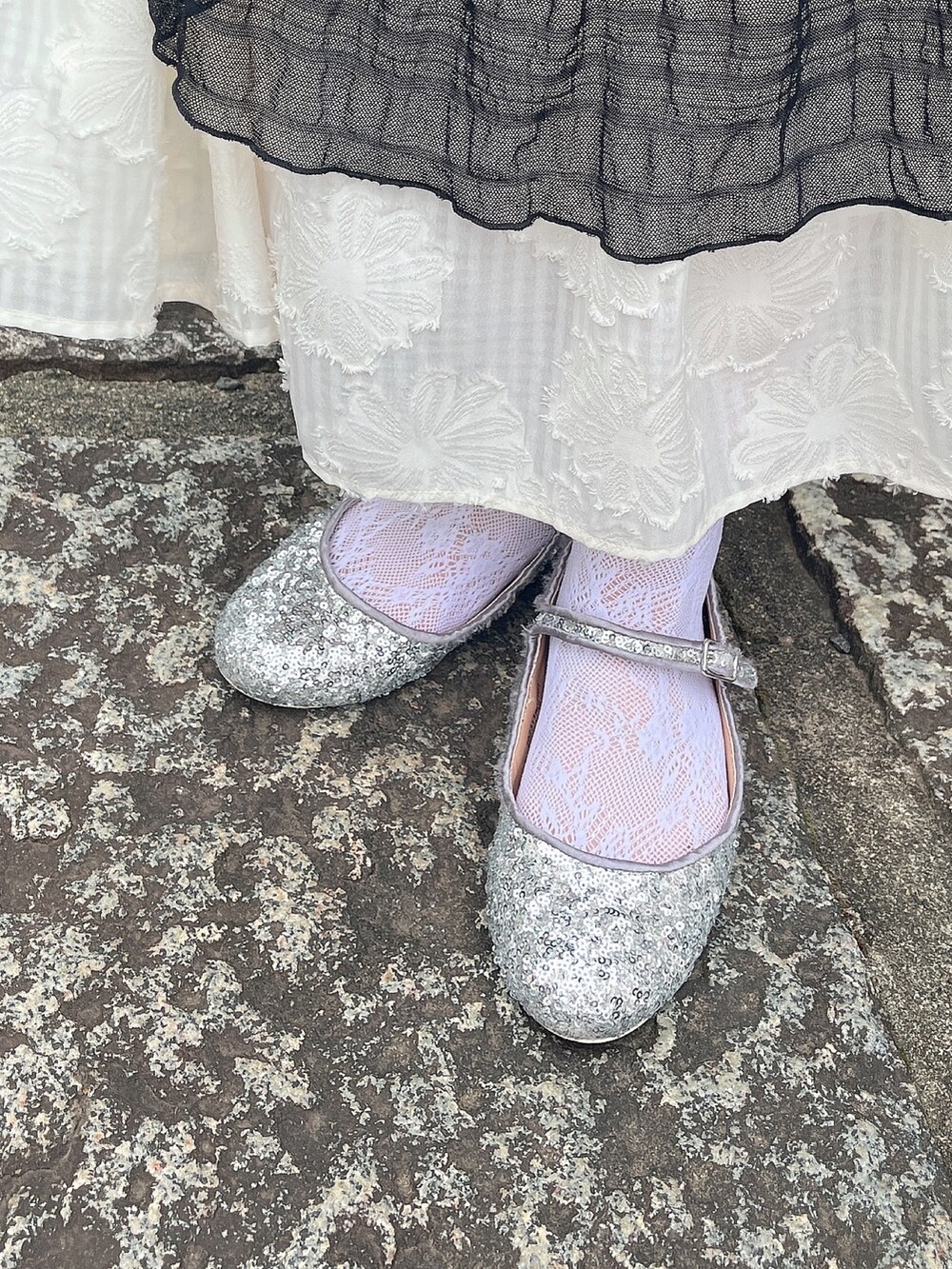 ブラック系のTシャツ/カットソー、シルバー系のパンプス、ホワイト系のスカートを着用したレディースの夏コーディネートの6枚目の写真