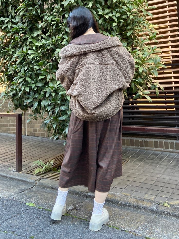 ブラウン系のカバーオール、ブラウン系のワンピース、ホワイト系のローファーを着用したレディースの冬コーディネートの3枚目の写真