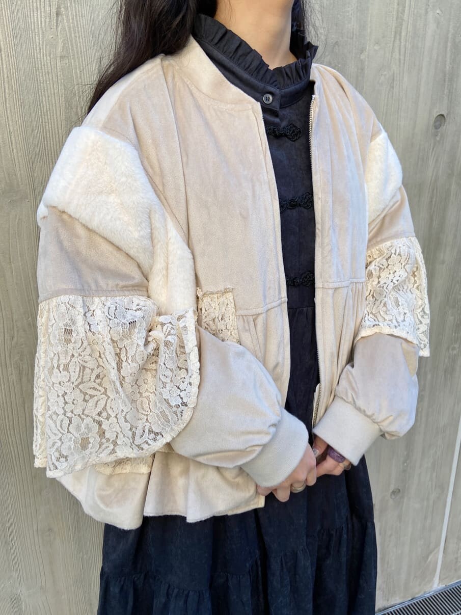 ホワイト系のブルゾン、ブラック系のワンピース、ホワイト系のスニーカーを着用したレディースの冬コーディネートの5枚目の写真