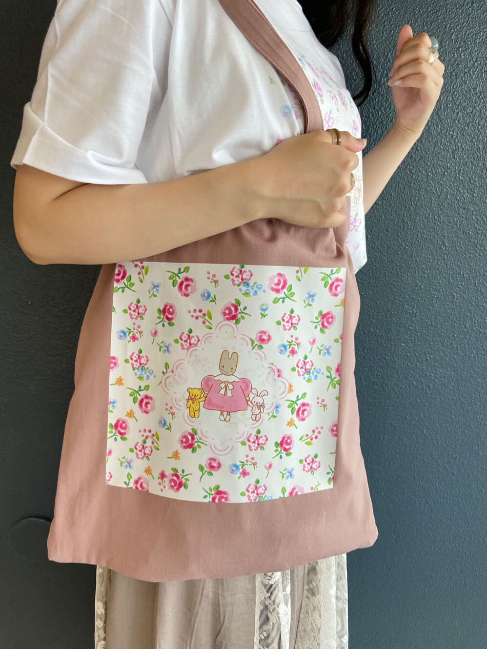 ベージュ系のスカート、ホワイト系のパンプス、ホワイト系のトートバッグを着用したレディースの夏コーディネートの6枚目の写真