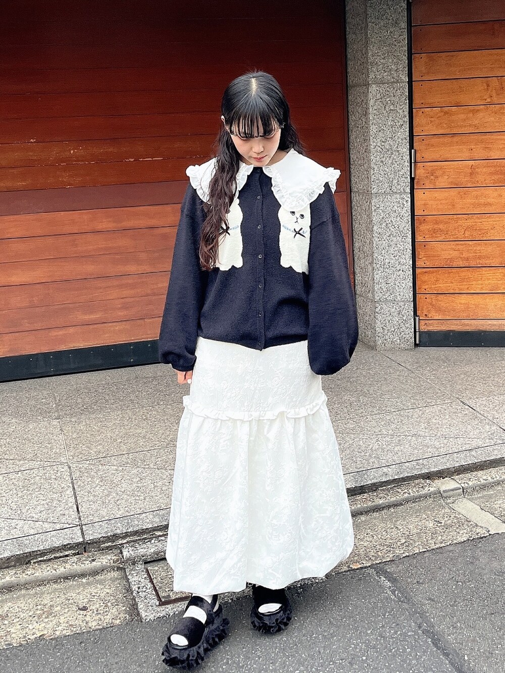 ホワイト系のスカート、ブラック系のカーディガン/ボレロ、ホワイト系のシャツ/ブラウスを着用したレディースの秋コーディネートの2枚目の写真