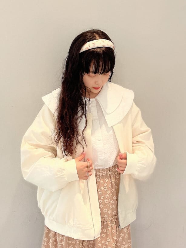 ホワイト系のブルゾン、ホワイト系のシャツ/ブラウス、ベージュ系のスカートを着用したレディースの秋コーディネートの4枚目の写真