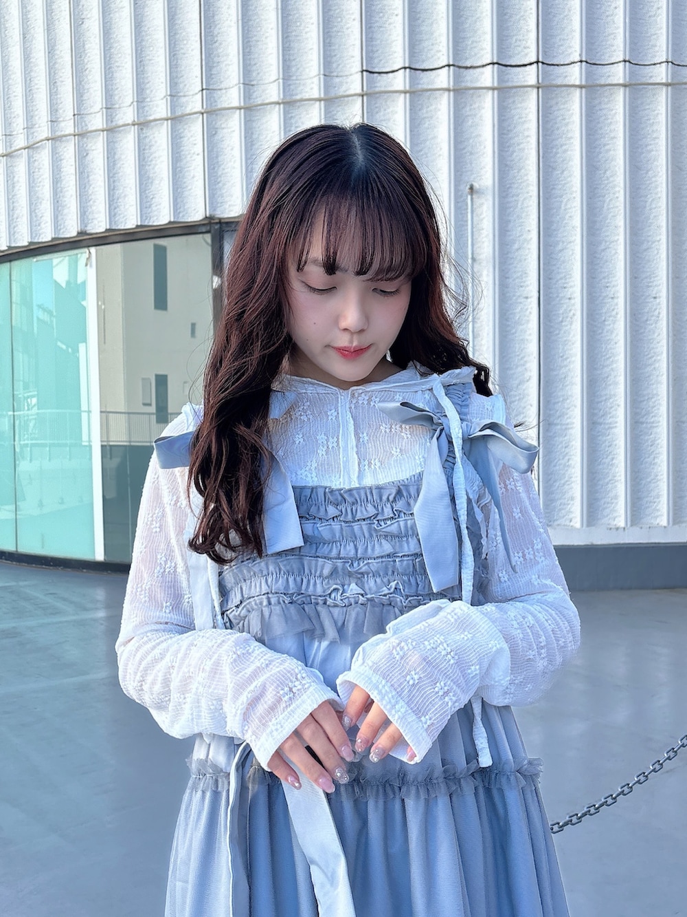 ホワイト系のTシャツ/カットソー、ブルー系のワンピース、ホワイト系のスニーカーを着用したレディースの冬コーディネートの4枚目の写真