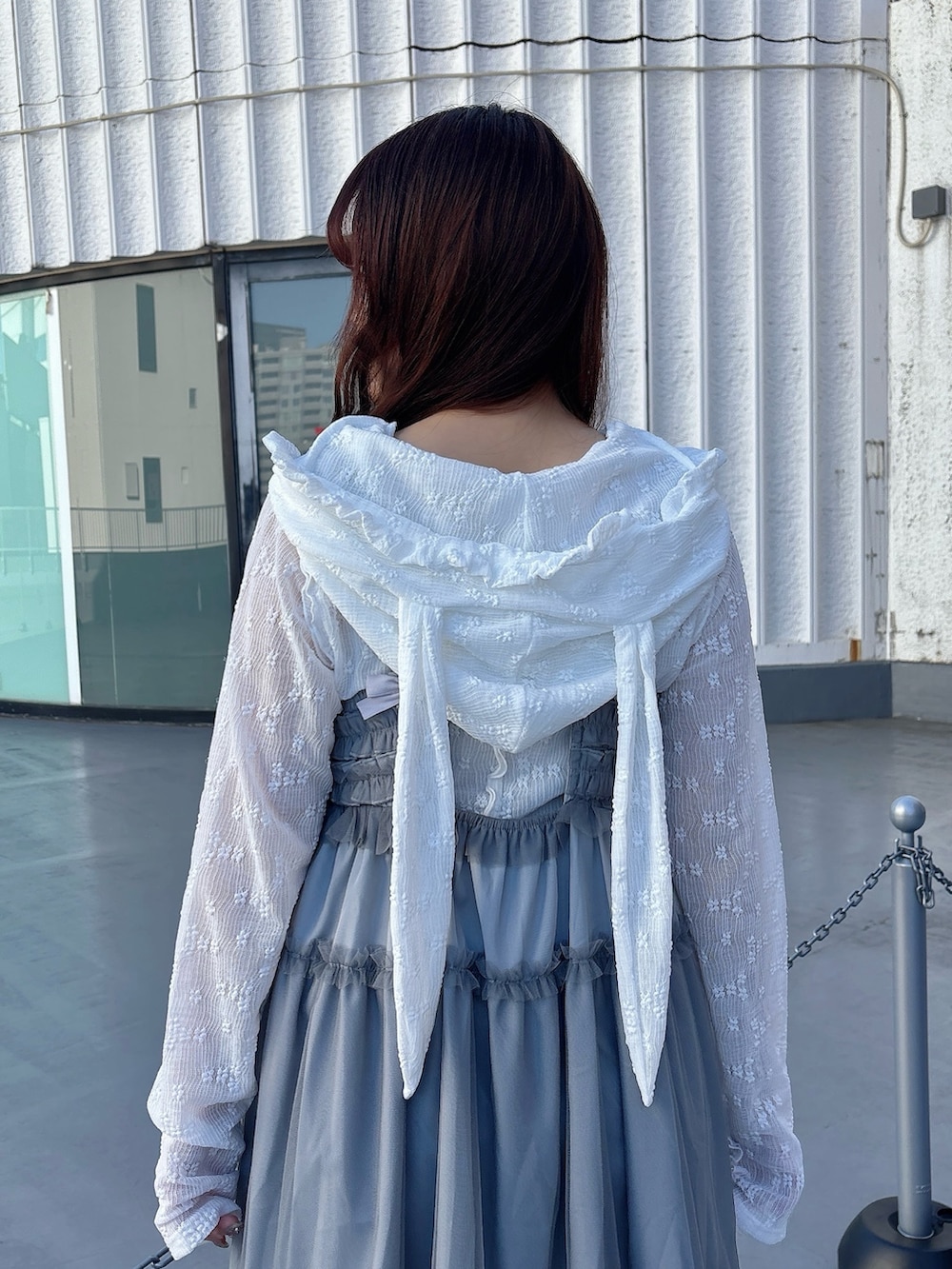 ホワイト系のTシャツ/カットソー、ブルー系のワンピース、ホワイト系のスニーカーを着用したレディースの冬コーディネートの5枚目の写真