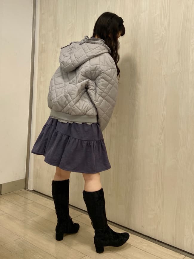 ブルー系のナイロンジャケット、パープル系のワンピース、ブラック系のブーツを着用したレディースの冬コーディネートの2枚目の写真