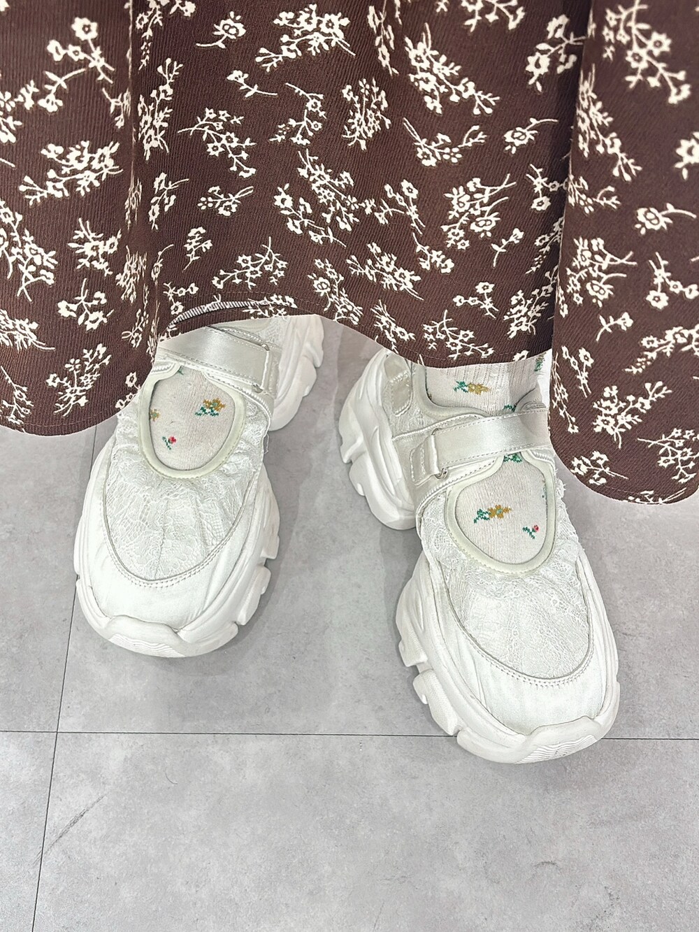 ホワイト系のニット/セーター、ホワイト系のカーディガン/ボレロ、ブラウン系のワンピースを着用したレディースの秋コーディネートの6枚目の写真